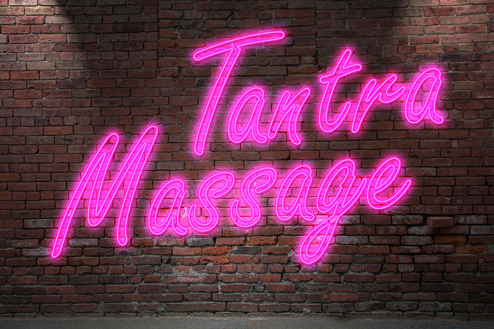 Ziegelwand mit rosa Leuchtschrift Tantra Massage