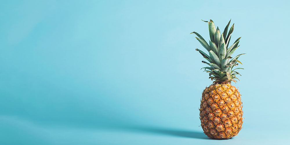 Ananas vor hellblauem Hintergrund