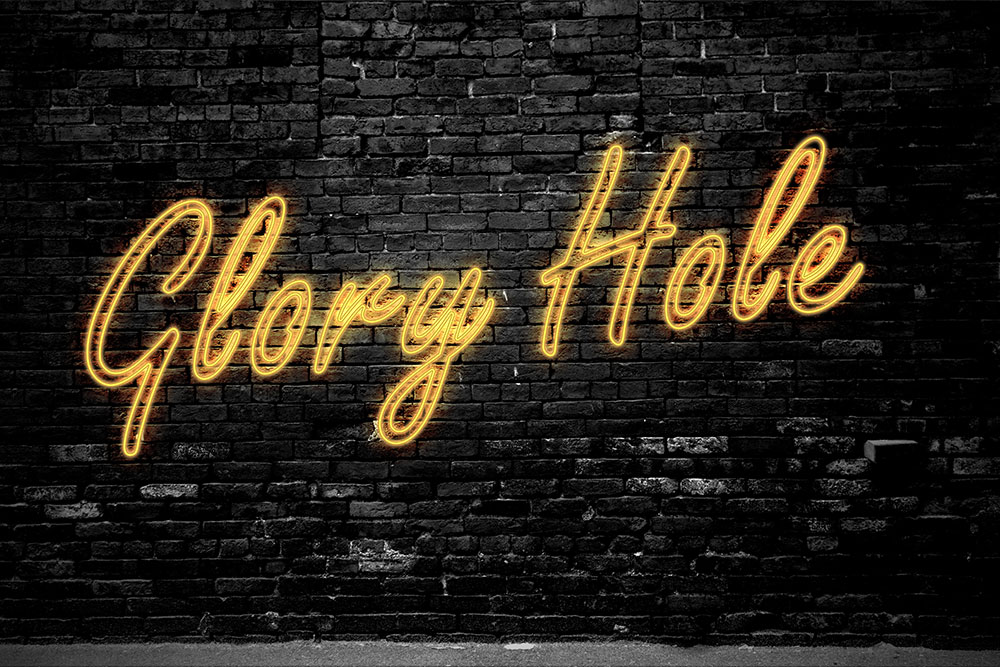 Schwarze Ziegelmaurer mit gelbem Leuchtschriftzug Glory Hole