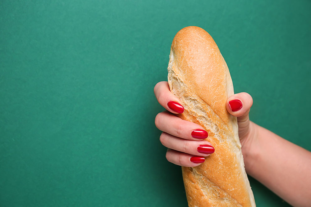 Baguette von einer Frau gehalten wie bei einem Handjob