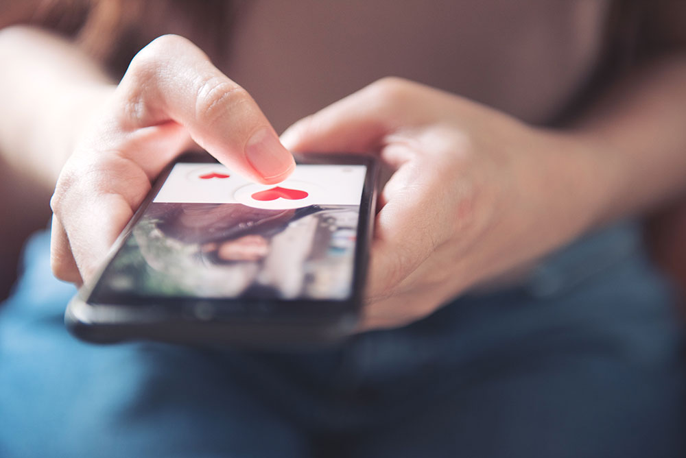 Hände mit Mobiltelefon mit geöffneter Dating-App