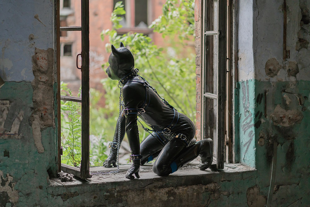 Person in Petplay-Kostüm in Fenster von Lost Place