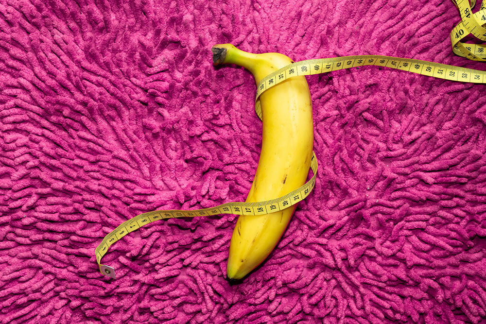 Banane eingewickelt in Maßband auf rosa Fransentuch - Symbolbild von YG PhotoArtWorks / stock.adobe.com